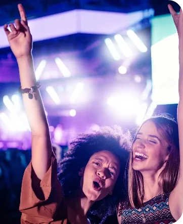 Imagen de dos chicas felices en un concierto